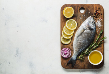 Raw Dorado fish on an old wooden cutting board prepared for cooking.