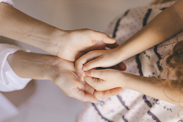 Selective focus and top view to hands of mom holds the palms of her child. 