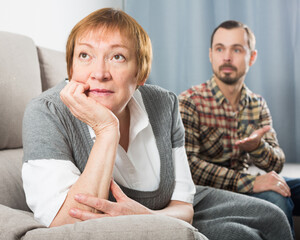 Aged mother arguing with her adult son at home