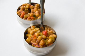 Delicious Indian chaat (salad) made of chickpeas, fruits, tomatoes, onion and different masalas in steel bowl ready to eat