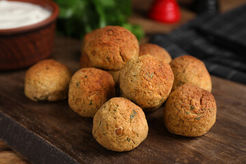 Delicious falafel balls on wooden board, closeup