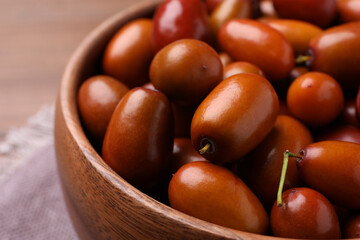 Fresh Ziziphus jujuba fruits in wooden bowl, closeup