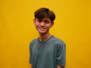 portrait of asian man with happy expression. with a yellow studio background.