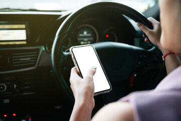 Empty mockup smartphone screen with clipping path. Asian young businesswoman using a smartphone while driving a car, careless woman driver using a phone while driving a car.