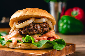 Fresh grilled homemade burgers with beef, tomato, fried egg, cheese and lettuce on rustic wooden...