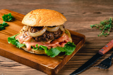 Fresh grilled homemade burgers with beef, tomato, fried egg, cheese and lettuce on rustic wooden background. fast food and junk food concept. fresh tasty burger on dark background.