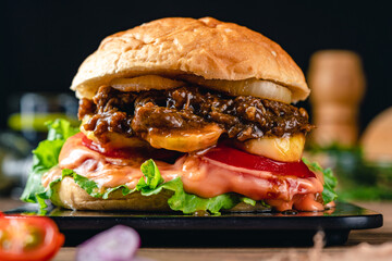 Fresh grilled homemade burgers with beef, tomato, fried egg, cheese and lettuce on rustic wooden background. fast food and junk food concept. fresh tasty burger on dark background.