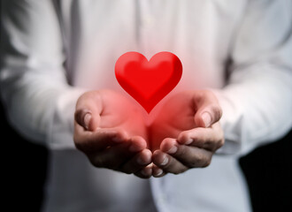 Close-up of man holding a red heart