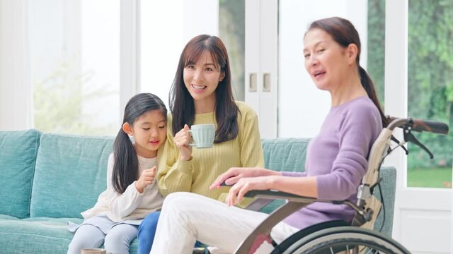 車椅子のシニア女性と親子　三世代家族