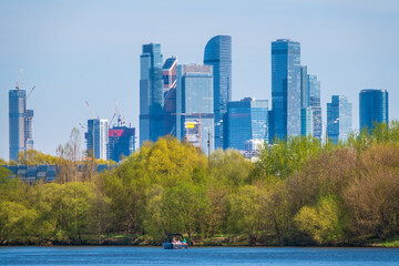 River and green trees on background modern skyscrapers in the Moscow city. Panorama of new Moscow City buildings in spring