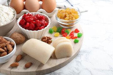 Marzipan and other ingredients for homemade Stollen on white marble table. Baking traditional German Christmas bread