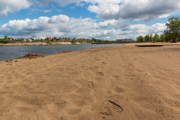 empty city beach with yellow sand on the river in summer in sunny weather