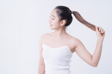 Woman holding hair on a white background. Attractive young woman over white background.