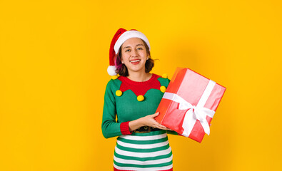 Portrait of Latin teenager girl holding Christmas gift box on a yellow background in Mexico latin america