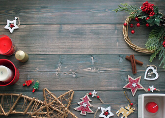 Christmas wreath with fir branches, cones and holly berries, Christmas toys, candle, cinnamon on a...