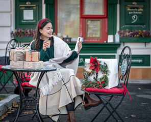 Attractive young woman uses smartphone, Christmas online shopping.