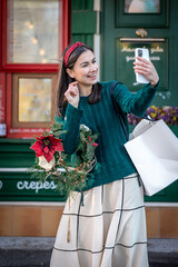 Happy young woman taking a selfie, preparing for the holiday of Christmas.