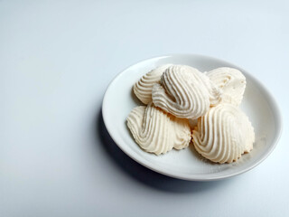 Spritz cookies, or custard cookies or roti semprit in Indonesian. Cookies shaped like a clam shell. Placed inside white small plate.