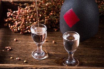 chinese liquor is pouring into a glass from a bottle on table