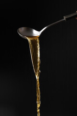 Dipper pouring noodle soup isolated on black background