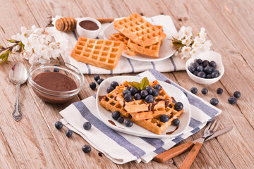 Waffles with blueberries and chocolate cream. 