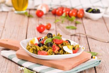 Fusilli pasta with cherry tomatoes, eggs and black olives.