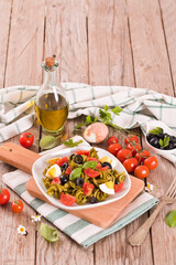 Fusilli pasta with cherry tomatoes, eggs and black olives.