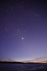 View of the starry sky over the Irtysh river covered with ice