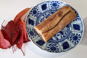 Bread on a blue plate with autumn leaves