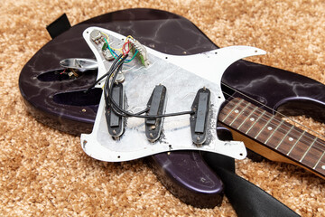 Broken electric guitar on the floor.