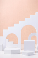 Geometric pedestal block on white table and pastel peach background.mockup for display product