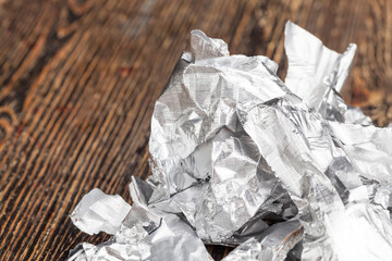 crumpled pieces of foil from chocolate on a wooden table
