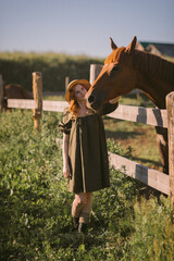 A girl with red hair strokes and feeds grass to horses 3245.