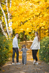 Fototapeta premium Dad, mom and daughter are walking in the autumn forest 3391.