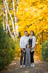 Fototapeta premium Dad, mom and daughter are walking in the autumn forest 3390.