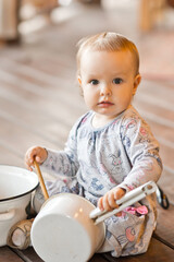 A little girl is playing with large pots and ladles 3458.