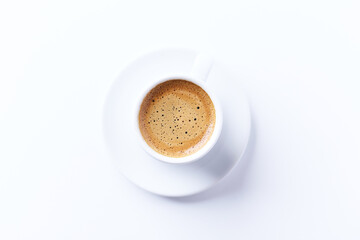 Cup of coffee on bright paper background. Top view. Close up. Copy space.