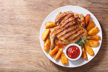 plate of grilled chicken with potatoes, top view