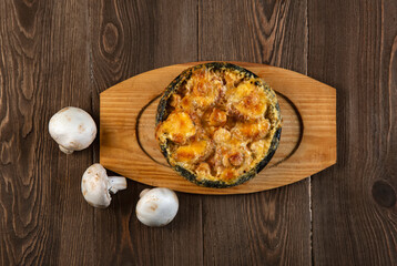 Julienne with cheese  and champignons on a wooden table. Homemade food. Healthy eating.