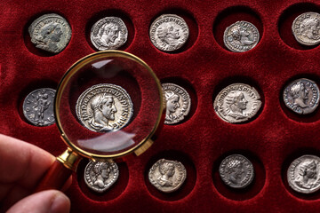 Numismatics.Authentic silver denarius, antoninianus of ancient Rome. A collector holds an old coin.Ancient coin of the Roman Empire - obrazy, fototapety, plakaty