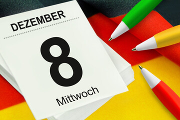 Kalender 8. Dezember 2021 und Kugelschreiber rot grün gelb mit Deutscher Flagge