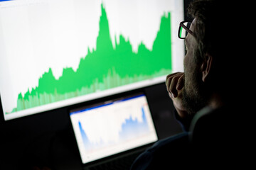 Crypto trader investor analyst looking at computer screen , thinking of online stock exchange market trading investment global risks.