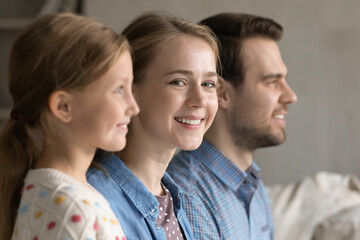 Focus on beautiful millennial woman looking at camera while cute little kid girl and handsome young man looking in distance, bonding friendly multigenerational family of three heredity, union concept.