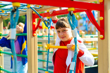 Fototapeta premium Happy girls play on ropes at playground area in summer