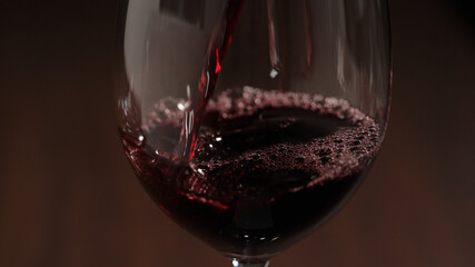 pour red wine into wineglass closeup