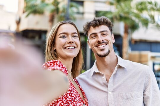 Young hispanic couple smiling happy making selfie by the camera at the city.