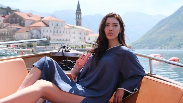 beautiful attractive woman posing on luxury boat. Beautiful woman posing on yacht in elegant summer dress. fashion model. attractive woman looking directly at camera