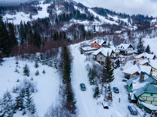 aerial view of the road in snowed village in the middle of carpathian mountains