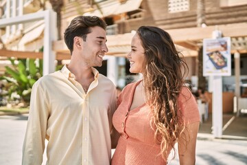Naklejka premium Man and woman couple smiling confident and hugging each other at street