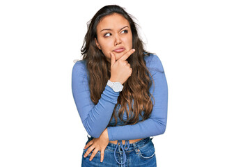 Young hispanic girl wearing casual clothes thinking worried about a question, concerned and nervous with hand on chin